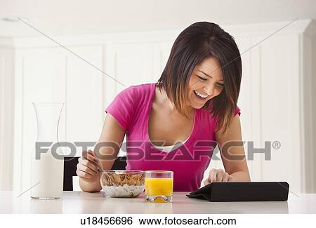 Young woman preparing breakfast View Large Photo Image Stock Photograph - Young woman preparing breakfast. Fotosearch