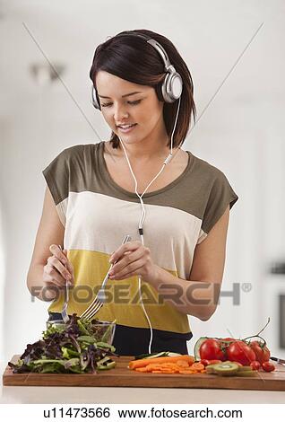 Stock Photograph - Young woman preparing salad. Fotosearch