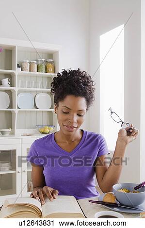 Stock Image - Young woman reading book. Fotosearch