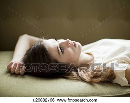 Young woman relaxing on sofa View Large Photo Image Stock Photograph - Young woman relaxing on sofa. Fotosearch