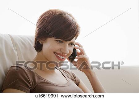 Young woman smiling and talking via mobile phone View Large Photo Image Stock Image - Young woman smiling and talking via mobile phone. Fotosearch