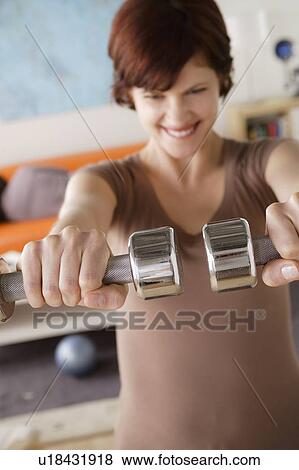 Young woman training at home, man sleeping on sofa View Large Photo Image Stock Photo - Young woman training at home, man sleeping on sofa. Fotosearch