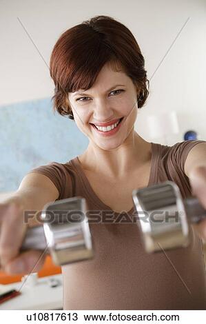 Young woman training at home View Large Photo Image Stock Image - Young woman training at home. Fotosearch
