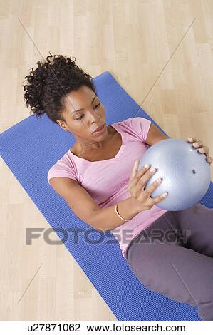 Young woman training at home View Large Photo Image Stock Image - Young woman training at home. Fotosearch