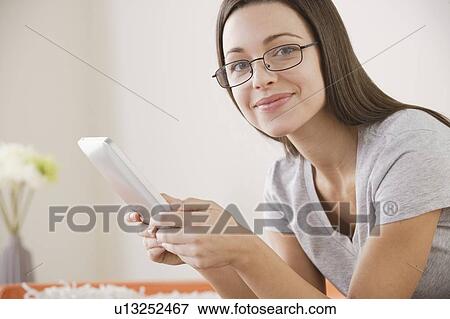 Young woman using digital tablet View Large Photo Image Stock Photo - Young woman using digital tablet . Fotosearch