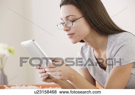 Stock Photo - Young woman using digital tablet . Fotosearch