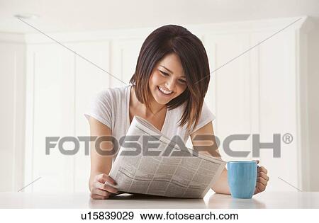 Young woman with newspaper and mug View Large Photo Image Stock Photo - Young woman with newspaper and mug. Fotosearch
