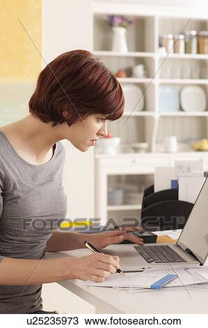 Young woman working at home View Large Photo Image Stock Image - Young woman working at home. Fotosearch