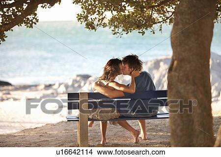 偶力がキスする 上に 公園のベンチ ピクチャー U Fotosearch