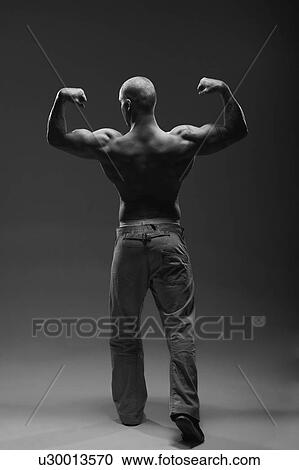 Athlete displaying arm muscles indoors View Large Photo Image Stock Image - Athlete displaying arm muscles indoors. Fotosearch