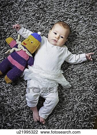 Baby laying on rug with stuffed animal View Large Photo Image Stock Image - Baby laying on rug with stuffed animal. Fotosearch