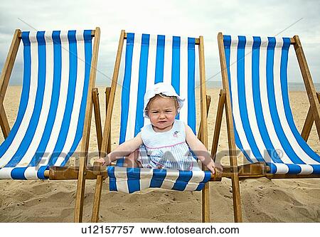 Stock Photo - Baby sitting in lawn chair on beach. Fotosearch