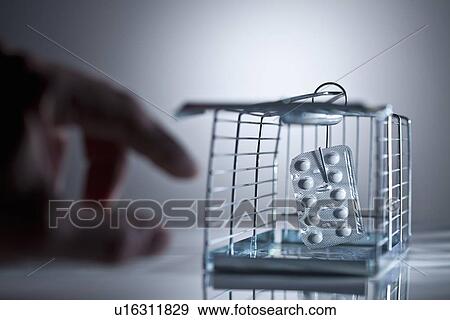 Blister pack of pills in cage trap View Large Photo Image Stock Photo - Blister pack of pills in cage trap. Fotosearch