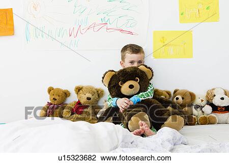 Boy hugging teddy bear on bed View Large Photo Image Stock Image - Boy hugging teddy bear on bed. Fotosearch