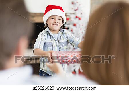 Stock Photo - Boy in Santa hat with Christmas gifts. Fotosearch