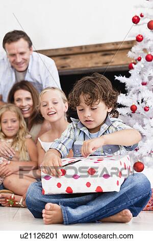 Boy opening Christmas gift View Large Photo Image Stock Image - Boy opening Christmas gift. Fotosearch