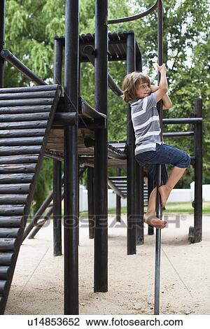 Stock Image - Boy playing on play structure. Fotosearch
