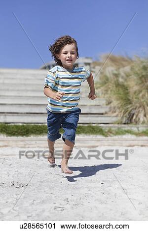 Boy running on sandy beach View Large Photo Image Stock Image - Boy running on sandy beach. Fotosearch