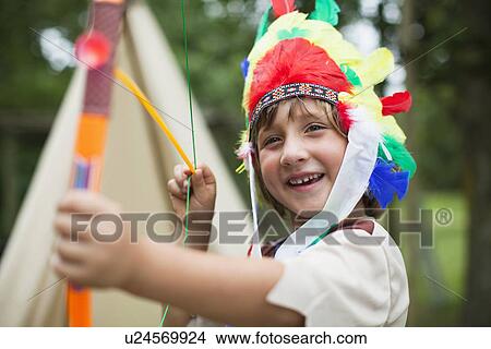 Boy with bow wearing Indian headdress View Large Photo Image Picture - Boy with bow wearing Indian headdress. Fotosearch