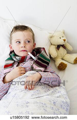Boy with thermometer in mouth in bed View Large Photo Image Stock Image - Boy with thermometer in mouth in bed. Fotosearch