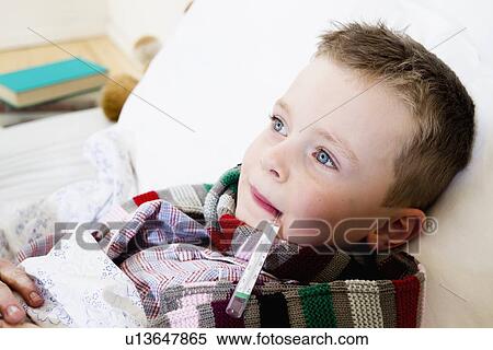 Boy with thermometer in mouth in bed View Large Photo Image Stock Photography - Boy with thermometer in mouth in bed. Fotosearch