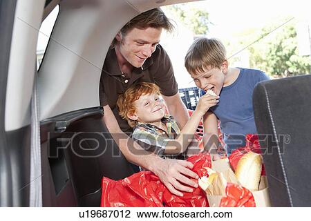 Boys eating groceries in trunk of car View Large Photo Image Stock Image - Boys eating groceries in trunk of car. Fotosearch