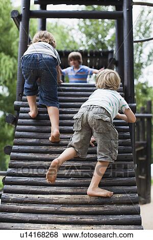 Boys playing on play structure together View Large Photo Image Stock Photo - Boys playing on play structure together. Fotosearch