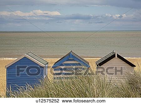 Stock Image - Brightly colored huts on beach. Fotosearch