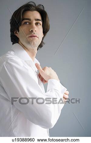Stock Image - Businessman buttoning his cuffs . Fotosearch