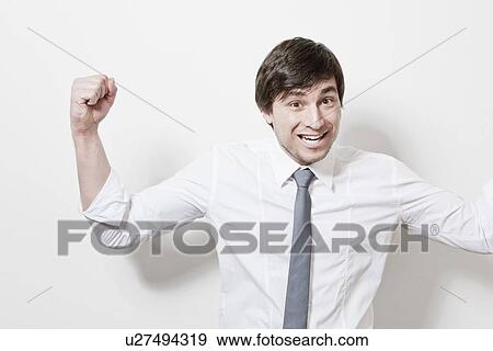 Businessman cheering in office View Large Photo Image Stock Photo - Businessman cheering in office. Fotosearch