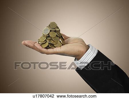 Businessman holding stack of Euro coins View Large Photo Image Stock Image - Businessman holding stack of Euro coins. Fotosearch