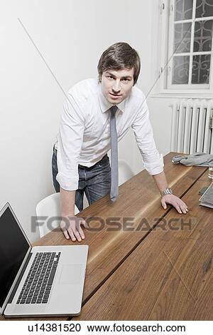 Businessman leaning over desk View Large Photo Image Stock Image - Businessman leaning over desk. Fotosearch