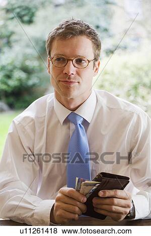 Stock Photo - Businessman taking money out of wallet. Fotosearch