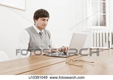 Businessman using laptop at desk View Large Photo Image Stock Photo - Businessman using laptop at desk. Fotosearch
