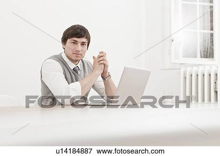 Stock Photo - Businessman using laptop at desk. Fotosearch