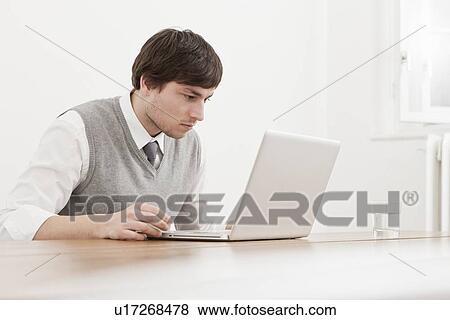 Businessman using laptop at desk View Large Photo Image Stock Photo - Businessman using laptop at desk. Fotosearch