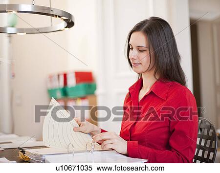 Stock Photography - Businesswoman organizing papers at desk. Fotosearch
