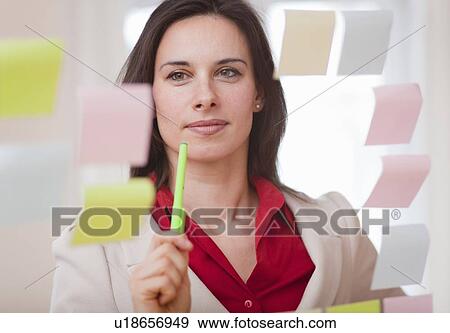 Stock Photo - Businesswoman reading sticky notes. Fotosearch