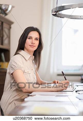 Businesswoman writing at desk View Large Photo Image Stock Image - Businesswoman writing at desk. Fotosearch