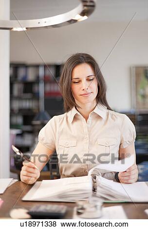Businesswoman writing at desk View Large Photo Image Stock Photo - Businesswoman writing at desk. Fotosearch