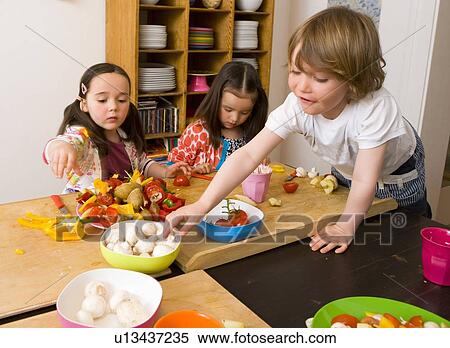 Stock Photography - Children cooking together in kitchen. Fotosearch