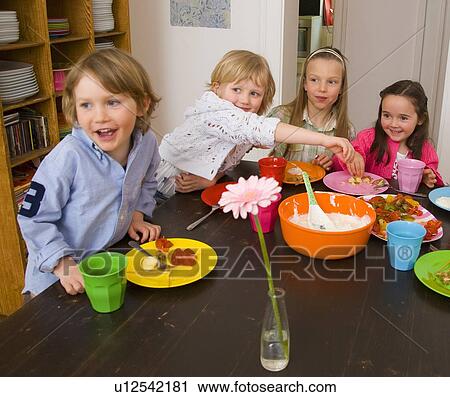 Children eating together at table View Large Photo Image Stock Image - Children eating together at table. Fotosearch