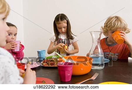 Children eating together at table View Large Photo Image Stock Image - Children eating together at table. Fotosearch