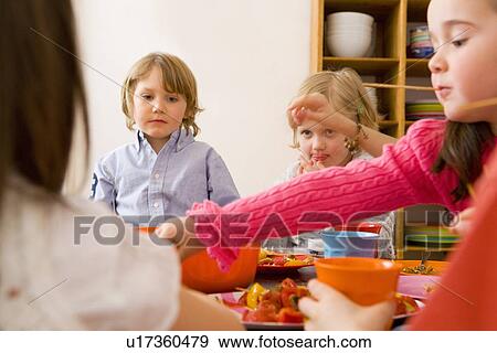 Children eating together at table View Large Photo Image Stock Photo - Children eating together at table. Fotosearch