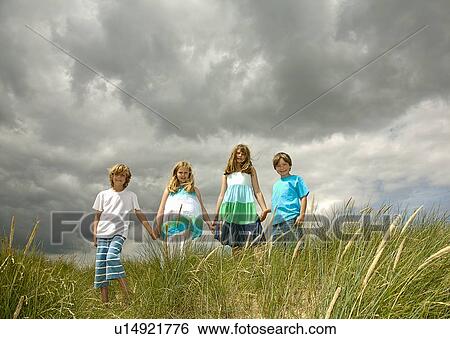 Stock Photograph - Children holding hands in field. Fotosearch