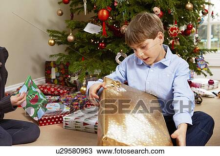 Stock Image - Children opening Christmas gifts. Fotosearch