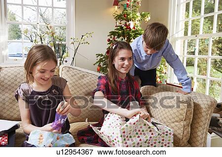 Stock Photo - Children opening Christmas gifts. Fotosearch