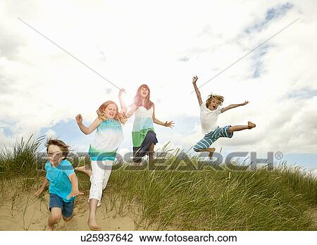 Children playing on grassy sand dune View Large Photo Image Stock Image - Children playing on grassy sand dune. Fotosearch