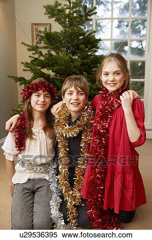 Stock Photography - Children playing with Christmas tinsel. Fotosearch