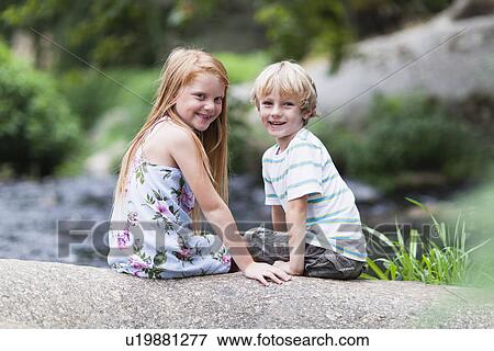 Children sitting on rock together View Large Photo Image Stock Photo - Children sitting on rock together. Fotosearch
